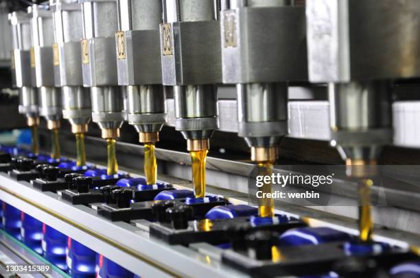 lubricating oil filling and packaging production line - oil flow stockfoto's en -beelden