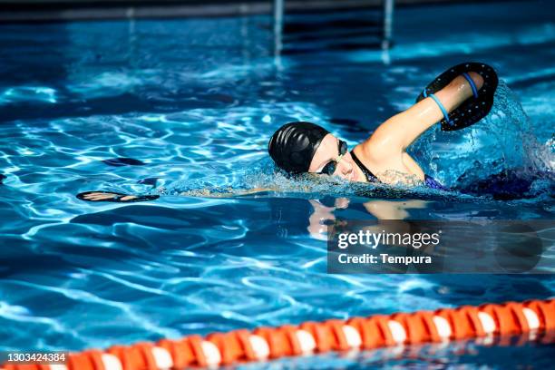 adaptive athlete swimmer training with paddles - woman swimmer freestyle stock pictures, royalty-free photos & images