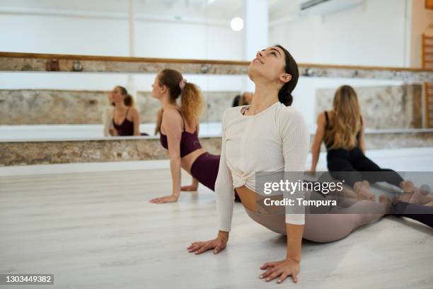 donne che fanno esercizi di stretching allo studio di yoga. - barre fitness foto e immagini stock