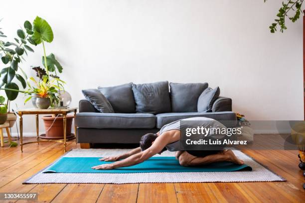 man in childs pose at home - ordinary guy stock pictures, royalty-free photos & images