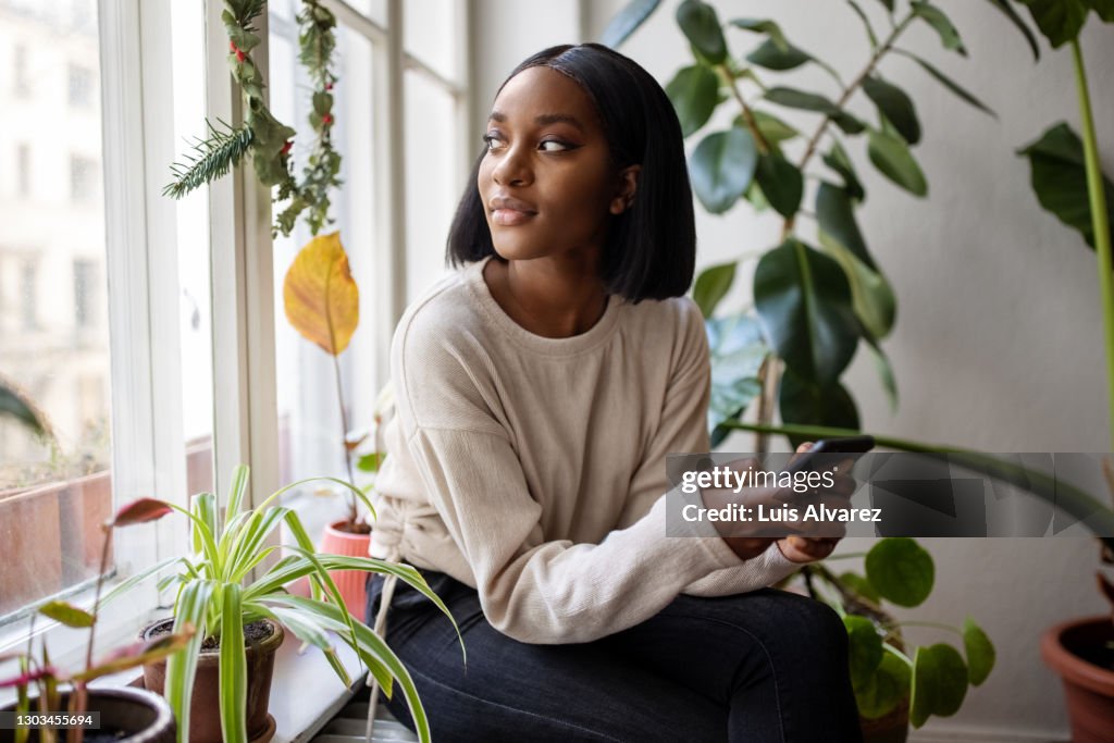 Woman at home looking outside window