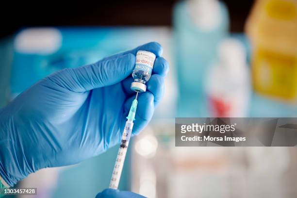 a healthcare worker prepares a dose of covid-19 vaccine. - coronavirus fotografías e imágenes de stock