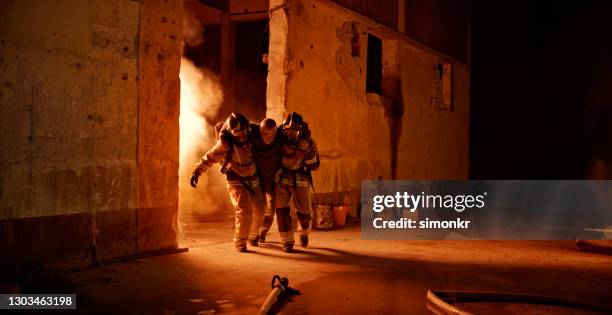 senior man being rescued by firefighters - burning stock pictures, royalty-free photos & images