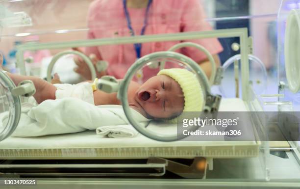 close up face asian newborn baby crying in an incubator  first day in the world - premature baby incubator stock-fotos und bilder