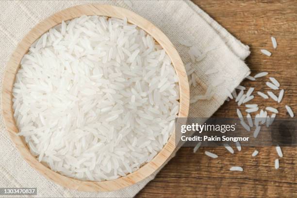 rice in a wooden bowl on wooden table - rice bowl above stock pictures, royalty-free photos & images