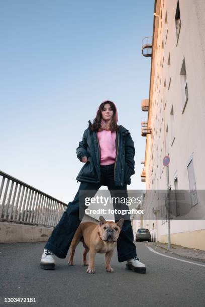 Teenage girl portrait with french bulldog, urban background