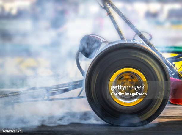 spinning rear wheel of a dragster - carrera de coches trucados fotografías e imágenes de stock