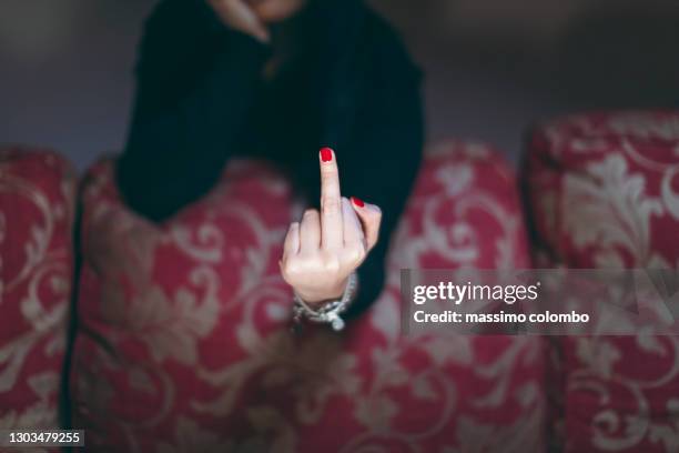 young woman showing middle finger with red nail polish - v sign stock pictures, royalty-free photos & images