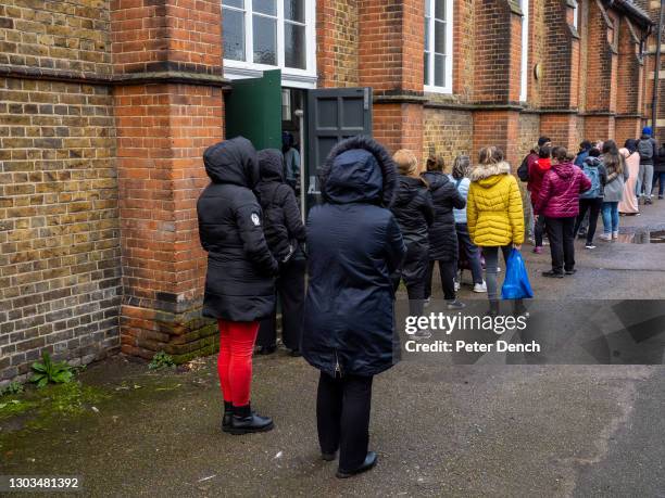 Beneficiaries queue at the Bounds Green Food Bank at St Michael's Hall on February 02 ,2021 in London, England. The food bank was established in June...
