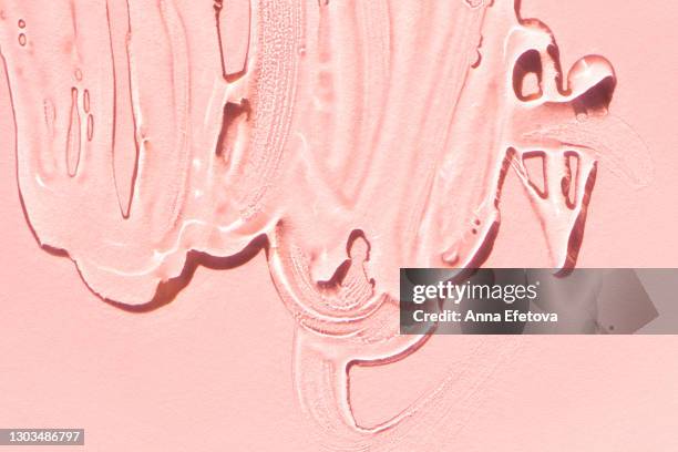 close-up top view of clean gel for skin care procedure smeared on pink background. trendy products of the year - lubricación fotografías e imágenes de stock