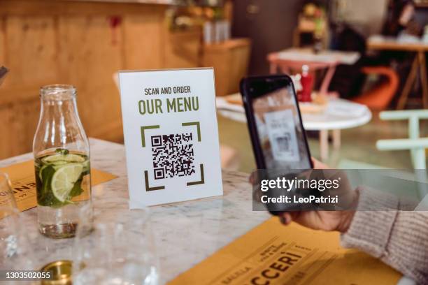 frau, die das restaurantmenü mit qr-code berät - speisekarte stock-fotos und bilder