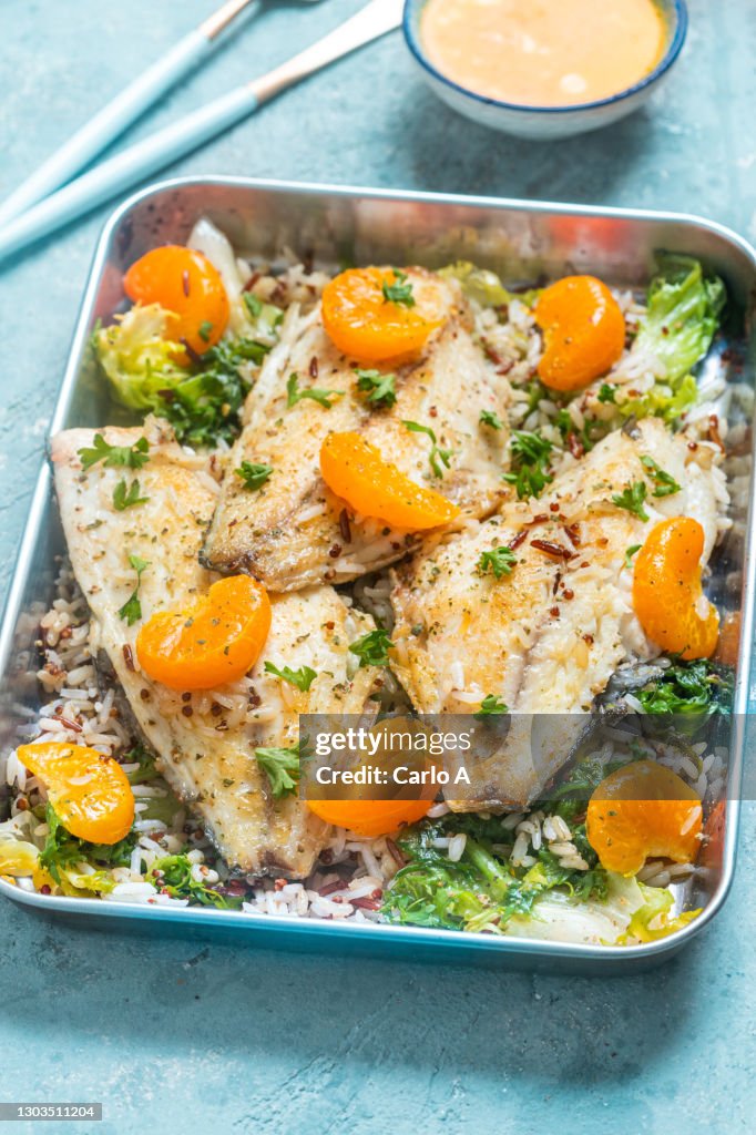 Baked fish fillet  with rice  tangerines and kale