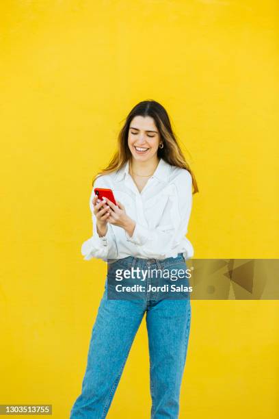 young girl using a red smartphone - woman talking cellphone stock-fotos und bilder
