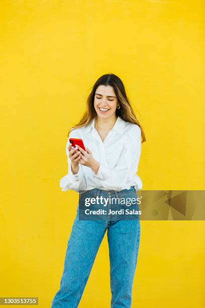 young girl using a red smartphone - happy teenagers phone stock pictures, royalty-free photos & images