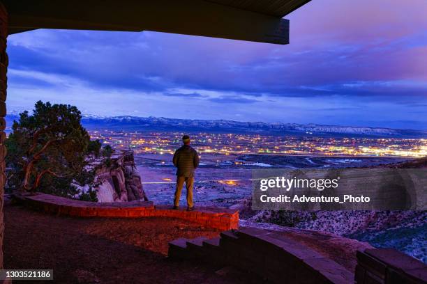 standing on rocks overlooking grand junction colorado at night - grand junction colorado stock pictures, royalty-free photos & images