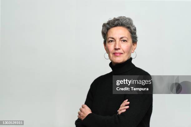 one woman with arms crossed over her chest looking at the camera. - retrato imagens e fotografias de stock