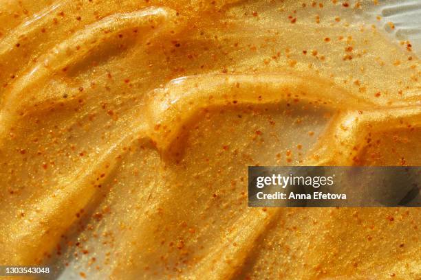 texture of illuminating orange scrub with exfoliating particles. selfcare is a trendy procedure of the year. cosmetics banner with copy space - body scrub stock-fotos und bilder