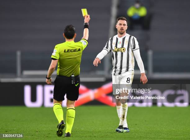 Aaron Ramsey of Juventus is shown a yellow card during the Serie A match between Juventus and FC Crotone at Allianz Stadium on February 22, 2021 in...