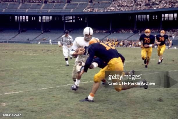Bob Washko of the Penn State Nittany Lions runs with the ball as Bob Hickey of the Illinois Fighting Illini gets ready for the tackle during an NCAA...