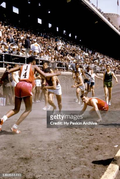 College team tries to pass the baton but falls during the track and field 64th Annual Relay Carnival on April 25, 1958 at Franklin Field in...