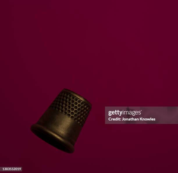 thimble on red background - thimble stock pictures, royalty-free photos & images