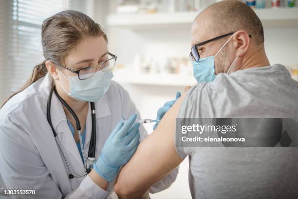 doctor and patient in a medical office - russia vaccine stock pictures, royalty-free photos & images