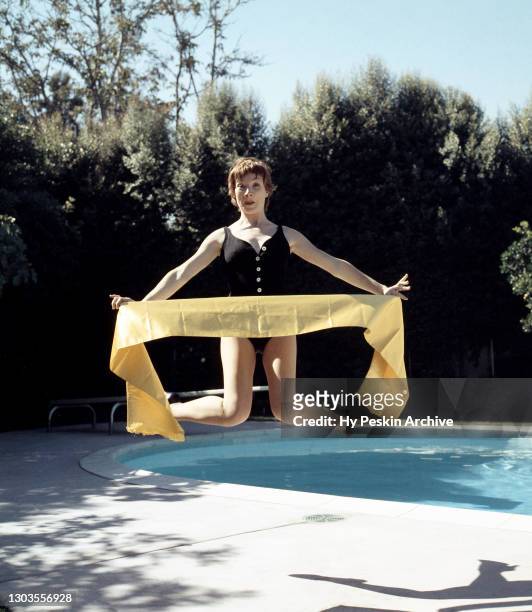 American film and television actress Shirley MacLaine poses for a portrait during a portrait session next to a swimming pool circa 1958.