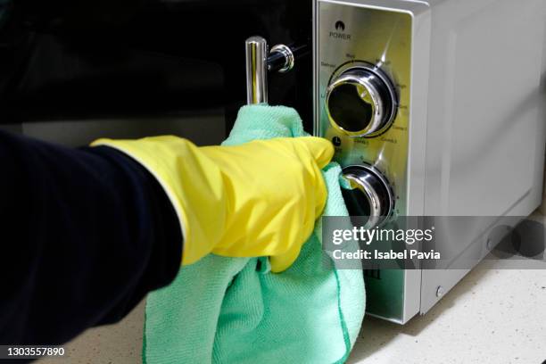close-up of hand with rubber glove cleaning microwaves - microwave photos et images de collection