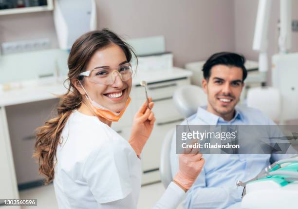 beim zahnarzt - dental hygienist stock-fotos und bilder