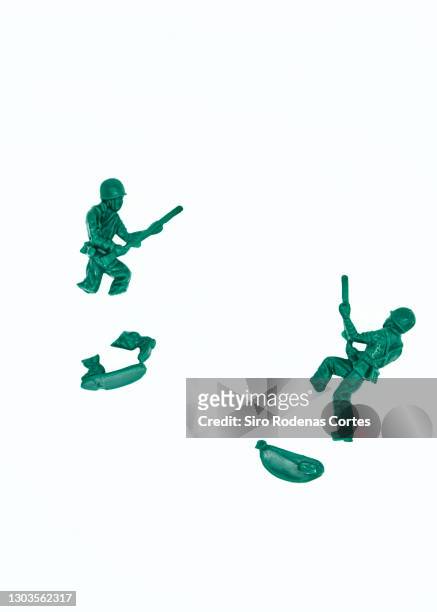 broken plastic toy soldiers on white background - broken figurine stock pictures, royalty-free photos & images