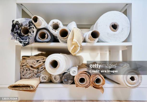rolls of fabric of different colors on a shelf - fabric rolls photos et images de collection