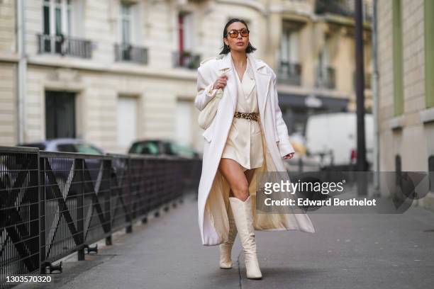 Yoshino Mia wears brown clear sunglasses from Vehla eyewear, a white long trench wool coat designed by herself, a white oversized long blazer double...