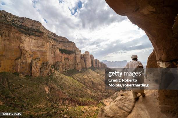 rear view of priest walking on access trail to the rock-hewn abuna yemata guh church, gheralta mountains, tigray region, ethiopia, africa - abuna yemata guh church stock pictures, royalty-free photos & images