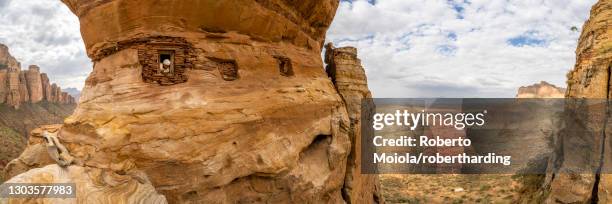 aerial panoramic by drone of priest looking out from abuna yemata guh rock-hewn church, gheralta mountains, tigray region, ethiopia, africa - abuna yemata guh church stockfoto's en -beelden