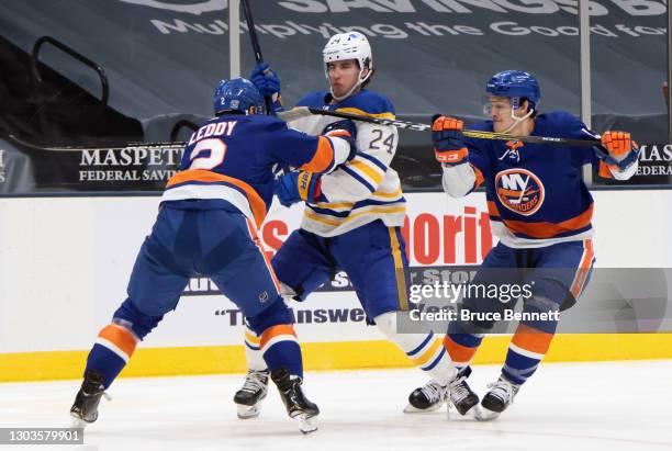 Nick Leddy and Mathew Barzal of the New York Islanders slow up Dylan Cozens of the Buffalo Sabres during the first period at the Nassau Coliseum on...