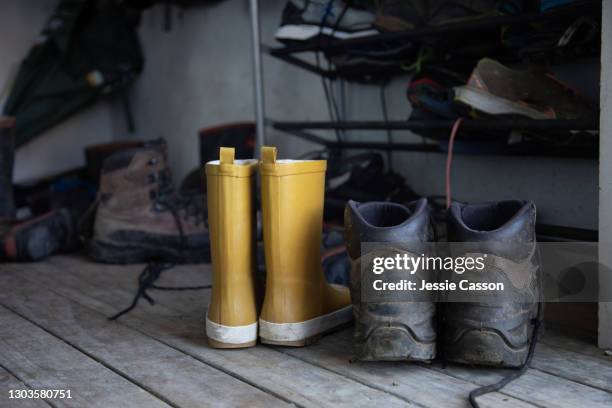 boots and shoes scattered on doorstep - yellow boot stock pictures, royalty-free photos & images