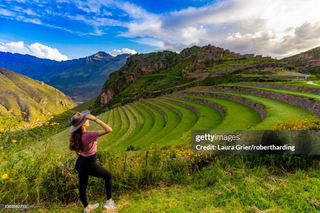 Girl gazing out at the mountain side Inca terraces at Pisac, Peru, South America