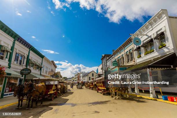 horse and carriage filled streets lined with beautiful colorful buildings, mackinac island, michigan, united states of america, north america - mackinac island stock-fotos und bilder