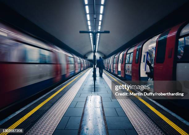 one stationary and one underground train in motion, london tube station, clapham common, clapham, london, england, united kingdom, europe - london underground speed stockfoto's en -beelden