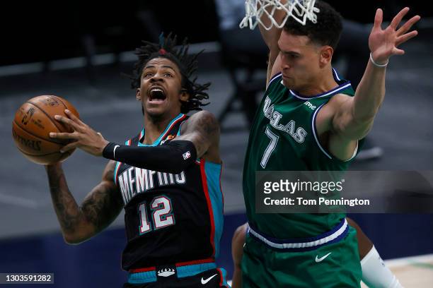 Ja Morant of the Memphis Grizzlies drives to the basket a draws the foul against Dwight Powell of the Dallas Mavericks in the first half at American...