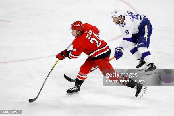 Jake Bean of the Carolina Hurricanes attempts a shot against Tyler Johnson of the Tampa Bay Lightning during the third period of their game at PNC...