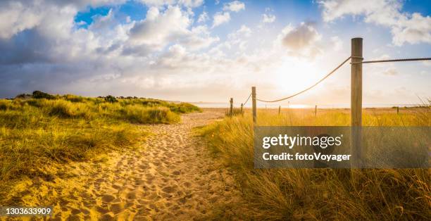 sandy path through summer dunes to idyllic ocean beach sunrise - jurassic coast world heritage site stock pictures, royalty-free photos & images