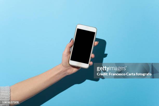 cropped hand of woman holding mobile phone - mano umana foto e immagini stock