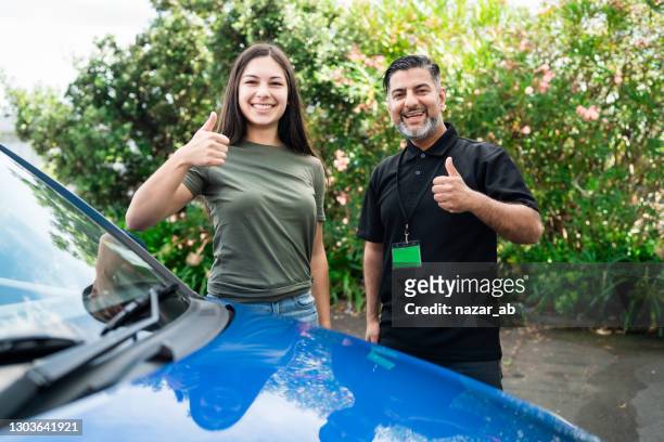 young woman delighted having just passed her driving test. - driving instructor stock pictures, royalty-free photos & images