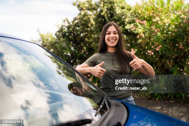 happy woman with thumbs up to buy a new car. - new cultures stock pictures, royalty-free photos & images