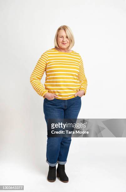 mature woman standing in studio - ganzkörperansicht stock-fotos und bilder