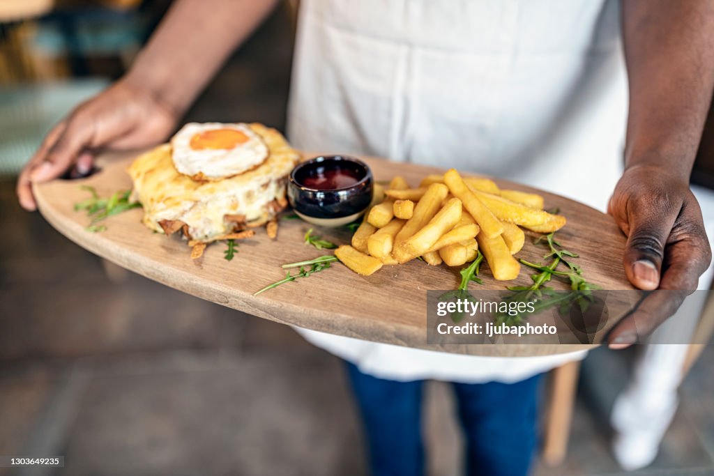 Chef Holding Burger met Friet en Ketchup op Houten Dienblad