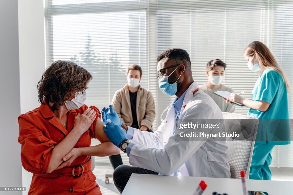 Women with face mask getting vaccinated, coronavirus, covid-19 and vaccination concept