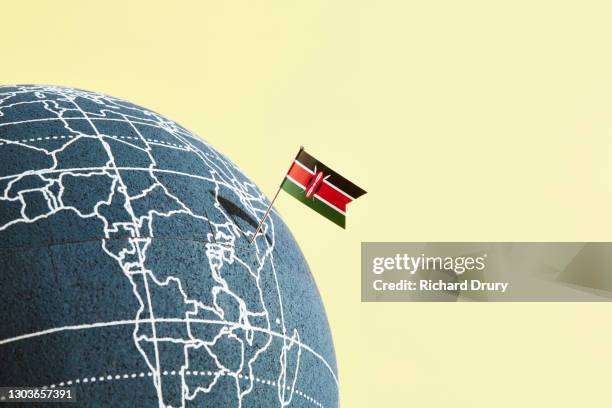 a world globe with a kenyan flag pin showing kenya - kenyan flag stock-fotos und bilder