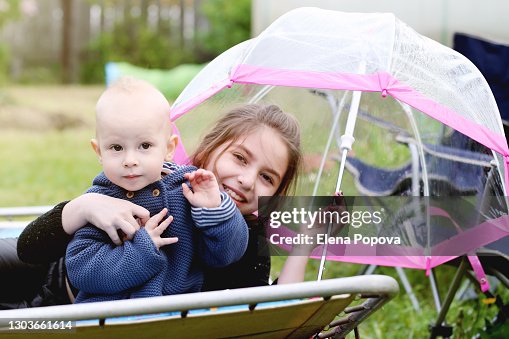 Cute Blond Toddler Boy Playing With His Sister At The Backyard Cute Blond Toddler Boy Playing With His Sister At The Backyard